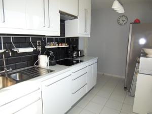 アルカションにあるAppartement Arcachon, 3 pièces, 4 personnes - FR-1-374-34の白いキャビネット、シンク、冷蔵庫付きのキッチンが備わります。