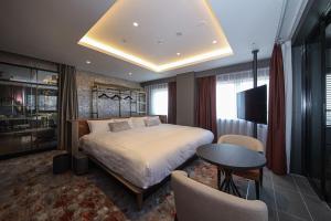 大阪的住宿－Spa World HOTEL&RESORT，卧室配有一张床和一张桌子及椅子