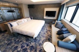 a bedroom with a large bed and a couch at Spa World HOTEL&RESORT in Osaka