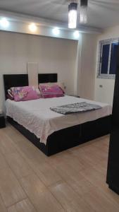 una camera da letto con un grande letto con cuscini rosa di Comfy Luxurious Apartment in Central Location in Mansheyet El Bakry East Cairo a Il Cairo