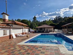 a dog is standing next to a swimming pool at Hospedaje Resguardo Real in Ráquira