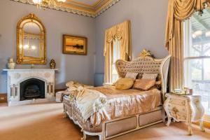 a bedroom with a bed with a fireplace and a mirror at Bishops Palace Ballarat in Wendouree