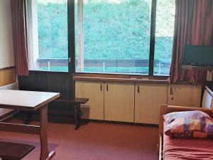 a room with a table and two large windows at Appartement Les Adrets-Prapoutel, 1 pièce, 4 personnes - FR-1-771-71 in Les Adrets