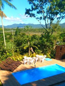 a resort with a pool and chairs and a view at Pousada Hang Conectada com a Natureza in Florianópolis