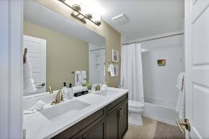 ein Badezimmer mit einem Waschbecken, einem WC und einem Spiegel in der Unterkunft Mtn View Oasis: 5bd - Movie/Game - Golden Tee in Superior