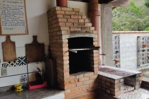 um forno de pizza de tijolo ao ar livre num quarto em Casa Chalé Chácara Caminho do Vale em Nova Friburgo