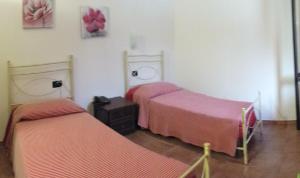 two beds in a bedroom with pink sheets at Azienda Agricola Cuntarati in Bronte