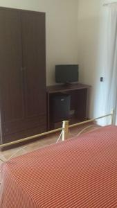 a bedroom with a bed and a desk with a television at Azienda Agricola Cuntarati in Bronte