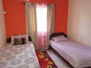 a bedroom with two twin beds and a window at Red Lory residences apartment G1 in Pereybere