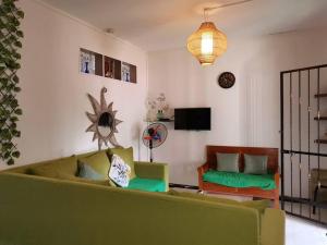 un salon avec un canapé vert et une télévision dans l'établissement Red Lory residences apartment G1, à Pereybere