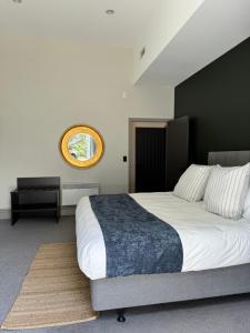 a bedroom with a large bed and a mirror at The Burlington Luxury Octagon Apartment in Dunedin