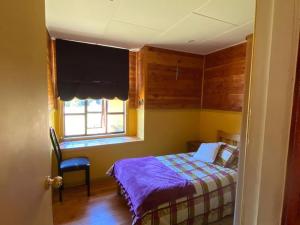 Habitación pequeña con cama y ventana en Casa acogedora en hermoso entorno Chiloe, en Rauco