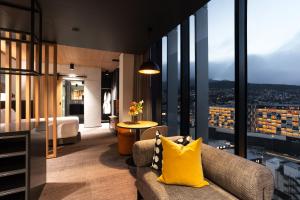 um quarto de hotel com um sofá e vista para a cidade em Mövenpick Hotel Hobart em Hobart