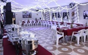 een feestzaal met tafels en witte stoelen en verlichting bij HOTEL PARADISE RIONEGRO in Rionegro