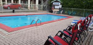 a large swimming pool with chairs in front of it at Riviera Inn And Suites 1000 Islands in Gananoque