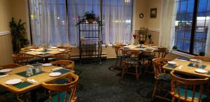 a dining room with tables and chairs and windows at Riviera Inn And Suites 1000 Islands in Gananoque