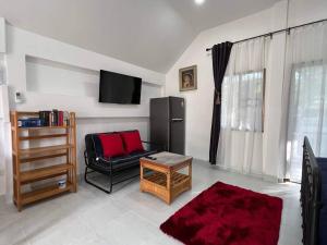 a living room with a black chair and a television at Charming Villa Suite with Balcony near Beach in Patong Beach