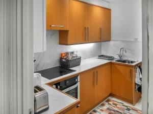 a kitchen with wooden cabinets and a sink at Harbour Way in Ilfracombe