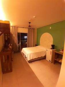 een slaapkamer met een bed en een groene muur bij Residencial Mãe terra in Bombinhas