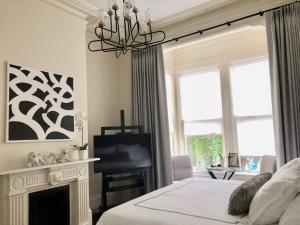 a bedroom with a fireplace and a bed and a chandelier at Pacific Heights Grand Elegant Studio in San Francisco