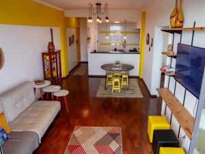 a living room with a couch and a table and a kitchen at Apto no Centro de Manaus com vista para o Rio Negro in Manaus