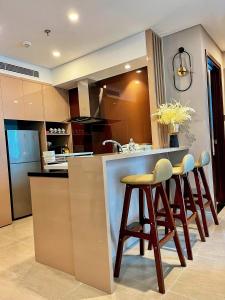 a kitchen with a bar with stools and a sink at Luxury 2Bedroom Apartment with Ocean view 25th Floor in Da Nang
