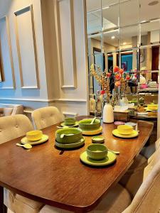 una mesa de comedor con platos amarillos y verdes. en Luxury 2Bedroom Apartment with Ocean view 25th Floor, en Da Nang