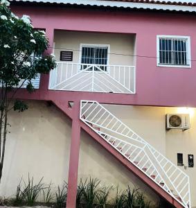 ein rosa Haus mit einer Treppe drauf in der Unterkunft Apartamento mobiliado em Barreirinhas MA in Barreirinhas