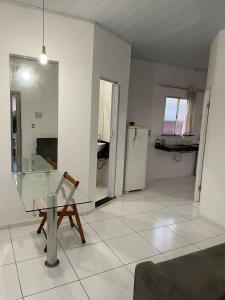 ein Wohnzimmer mit einem Glastisch und einem Kühlschrank in der Unterkunft Apartamento mobiliado em Barreirinhas MA in Barreirinhas