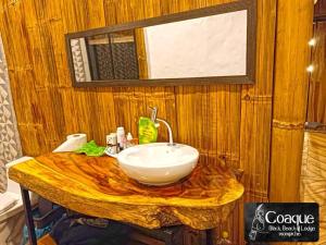 a bathroom with a sink on a wooden wall at Coaque black Mompiche in Mompiche