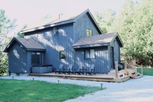 a blue building with benches on a deck at Secret Hideaway 4BED Lakefront w/Hotub in Sheshegwaning
