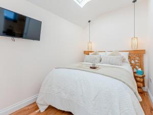 um quarto com uma cama e uma televisão na parede em The Hideaway em Great Meols