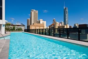 a swimming pool on top of a building with a city skyline at Private Apartments at Circle on Cavill - Q Stay in Gold Coast