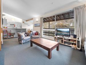 a living room with a coffee table and a tv at Tombarra 4B in Thredbo