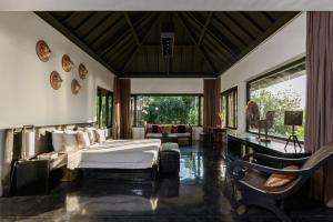 a bedroom with a bed and a living room at Villa Florimar - 50m to Seseh Beach in Canggu