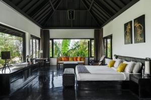 ein Wohnzimmer mit einem Bett und einem Sofa in der Unterkunft Villa Florimar - 50m to Seseh Beach in Canggu