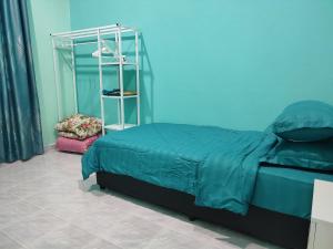 um quarto com uma cama e uma parede azul em Villa Tamu Dr Din - Pool OR Soopa Doopa em Rantau Panjang