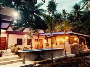 a house with a swimming pool in front of it at Palermos IslandVille in Catarman