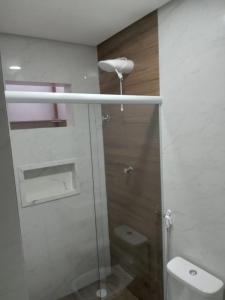 uma casa de banho com uma cabina de duche em vidro e um WC. em Hotel New Space em São Paulo
