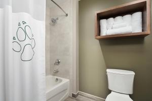 uma casa de banho com um WC e um chuveiro com toalhas em Great Wolf Lodge Mason em Mason