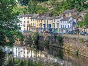 a row of houses next to a river in a town at The Stables - Uk13658 in Middleton