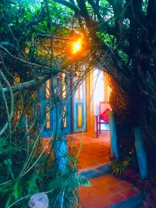 a room with a red chair and a tree at Serendipity Lake Artistic Bungalow by Heidis Home in Nuwara Eliya