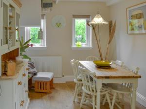 cocina con mesa de madera con sillas y comedor en Kielder Kip Cottage, en Kielder