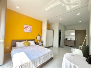 een slaapkamer met een bed en een gele muur bij Luxury Condotel Sai Gon 3 in Ho Chi Minh-stad