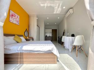 a bedroom with a bed and a yellow wall at Luxury Condotel Sai Gon 3 in Ho Chi Minh City