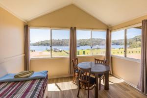 a room with a table and chairs and windows at Walpole Rest Point Caravan Park in Walpole