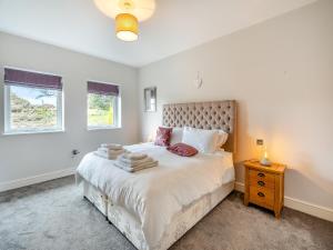 sypialnia z dużym łóżkiem i oknem w obiekcie The Cottage At Breeze Hill w mieście Storth