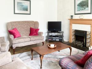 a living room with a couch and a fireplace at Sandy Bay in Portmahomack