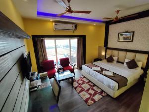a bedroom with a bed and a tv and a couch at Hotel Sagar Kanya INN in Puri
