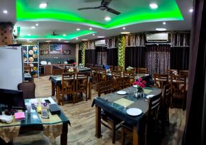 a restaurant with tables and chairs and a green ceiling at Hotel Sagar Kanya INN in Puri